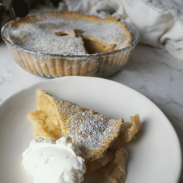 apple pie on a plate with whipped cream