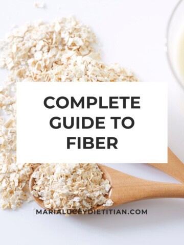Complete guide to fiber graphic with oats on a wooden spoon and a glass of milk in the background.
