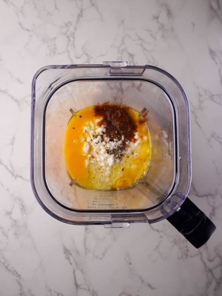 Eggs, cottage cheese and seasonings added to a blender to make the filling for tortilla egg cups.