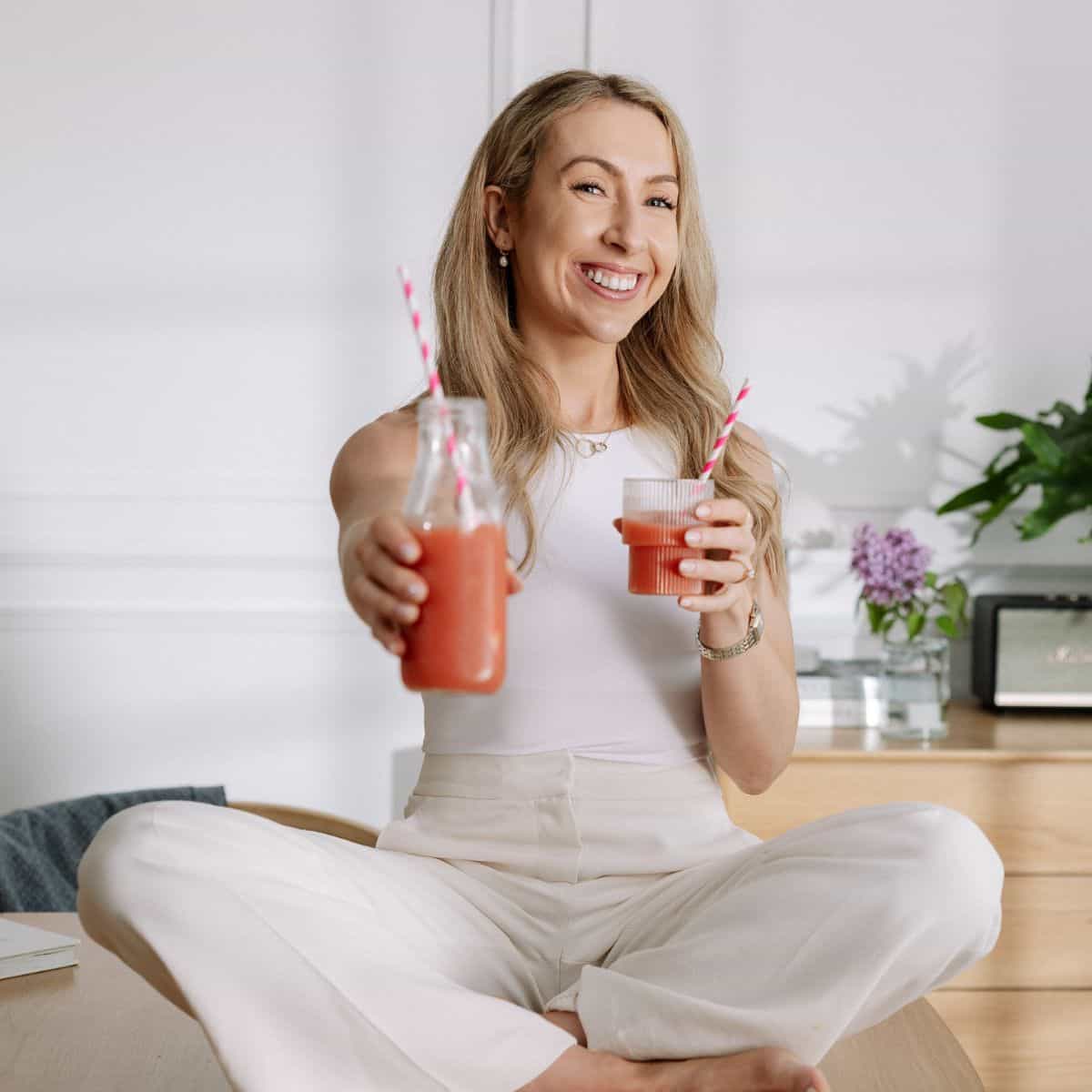 Maria Lucey, Registered Dietitian sitting on a table and holding a high protein smoothie.