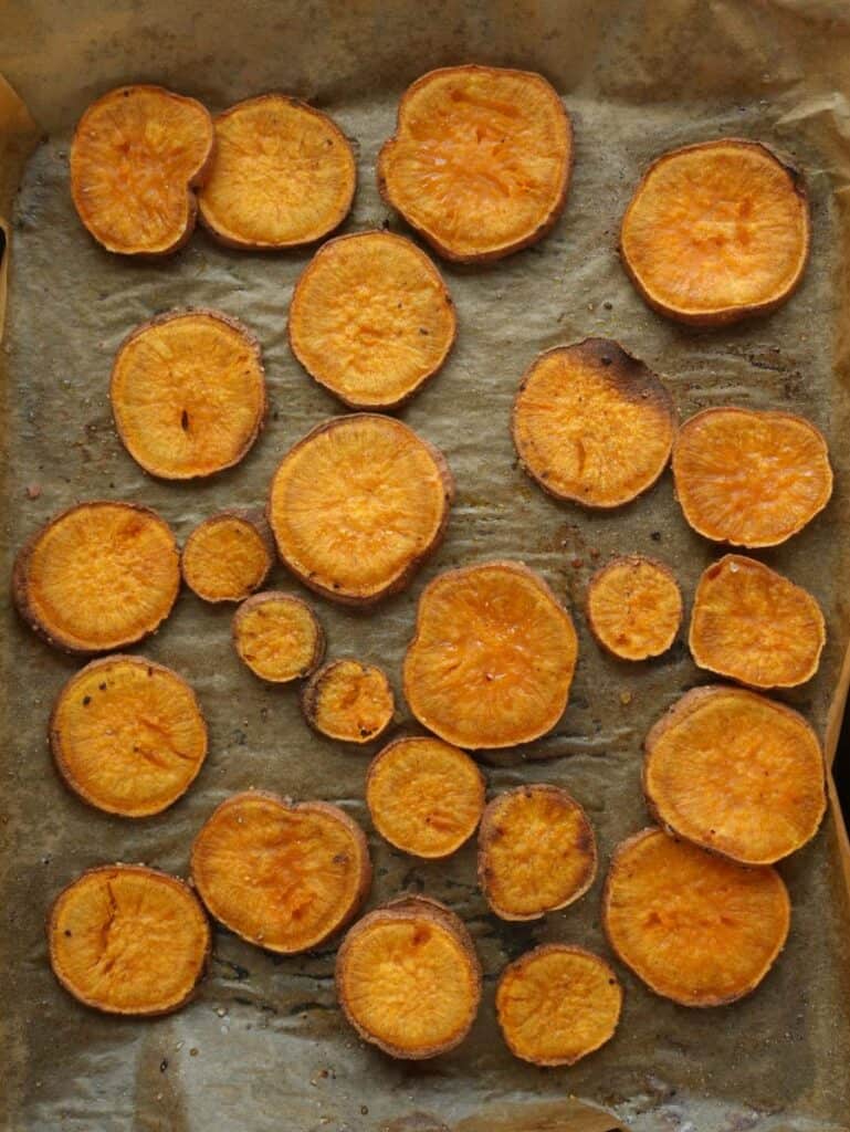 Golden roasted sweet potato rounds fresh out of the oven, slightly caramelized and crispy on the edges.