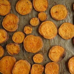 baked sweet potato slices on parchment paper on a baking tray.