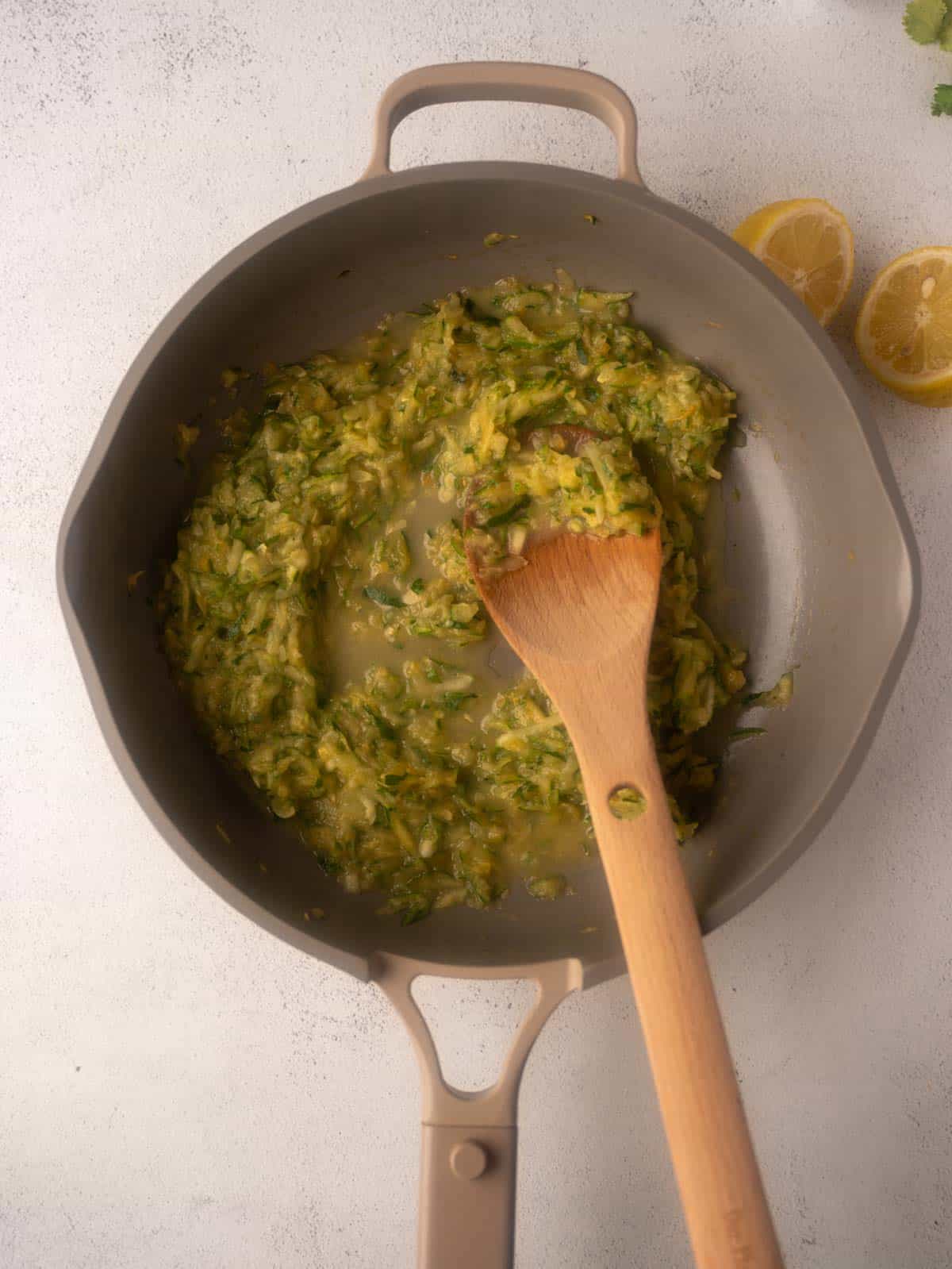Second step for the Pesto Ricotta Pasta recipe: sautéing the grated zucchini in a pan until it has softened and released its liquid.