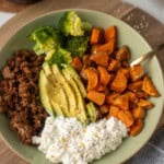 Sweet potato and ground beef bowl with broccoli, avocado, and cottage cheese that is plated nicely.