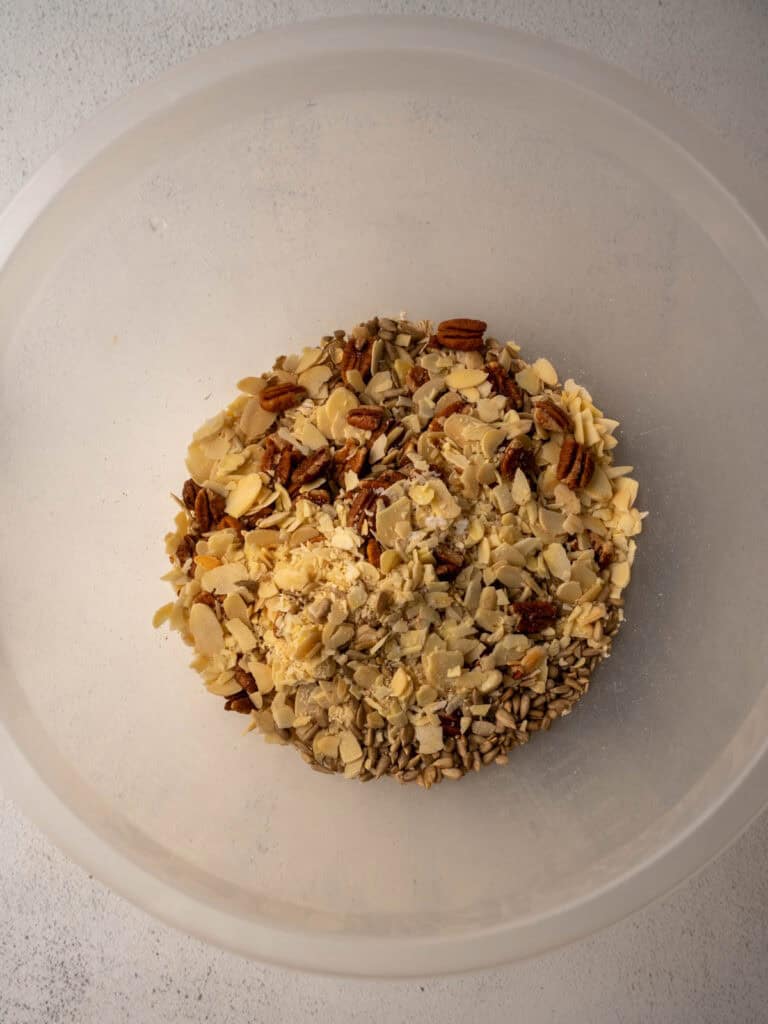 Bowl filled with chopped nuts and seeds for the granola recipe.