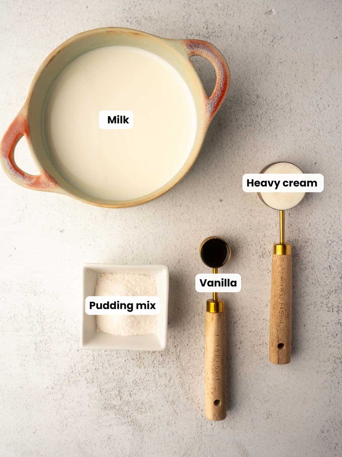 Ingredients for a Ninja Creami vanilla ice cream recipe including milk, heavy cream, vanilla, and pudding mix.