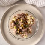 Healthy tuna salad recipe made with Greek yogurt, feta, pistachios, celery, red onion, and fresh dill, served in a glass bowl.