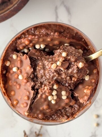 Chia seed protein pudding with a crunchy chocolate shell and crispy cereal pieces, with a spoon scooping through the center