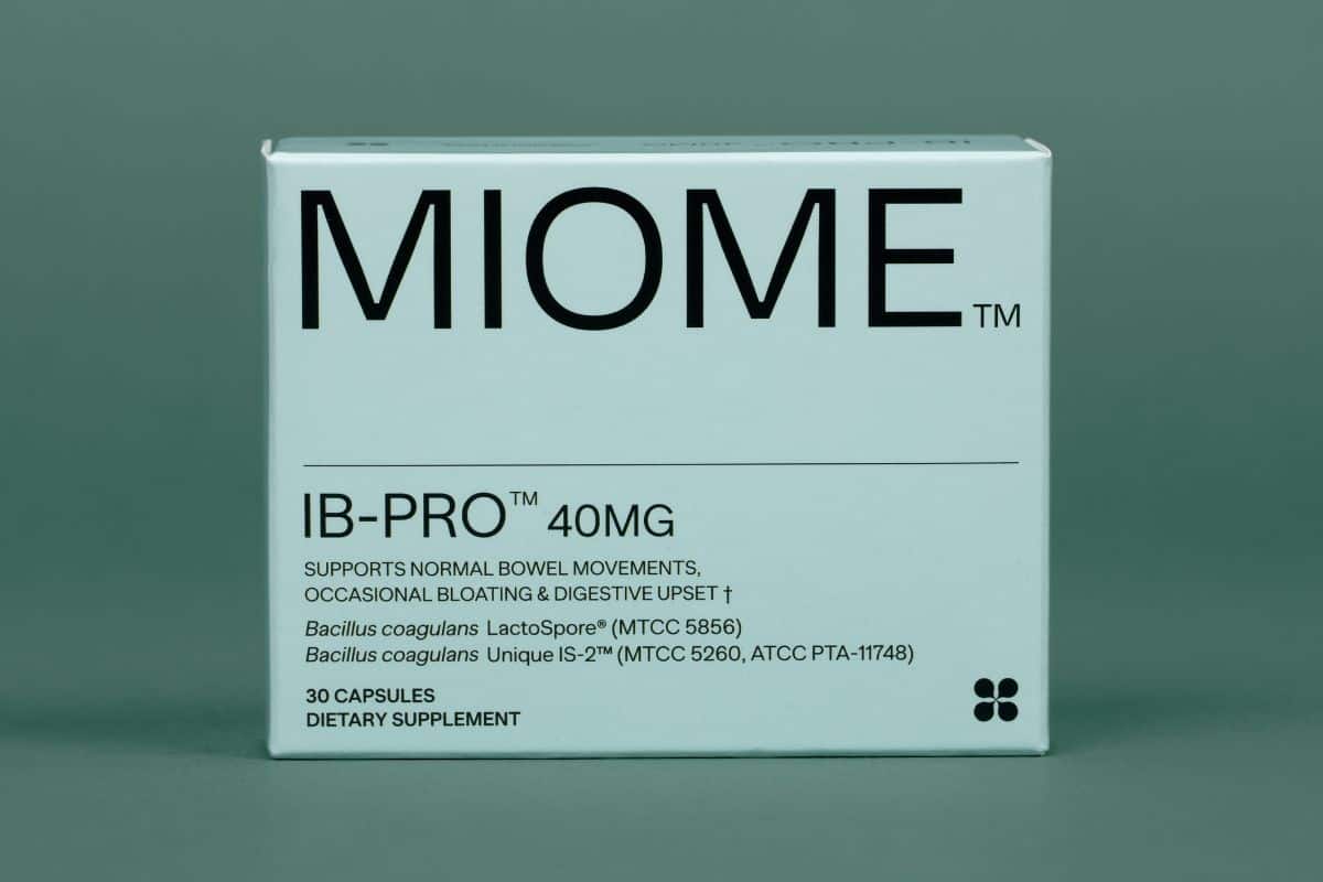 Box of MIOME IB-PRO probiotic supplement containing Bacillus coagulans and Lactospore strains on a teal background.