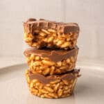 No bake chocolate peanut butter crispy cups with a bite showing crispy rice cereal texture and creamy chocolate topping