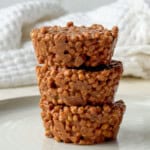 Pea protein chocolate crispie cakes stacked on top of each other with a crunchy chocolate coating made from puffed pea protein cereal.