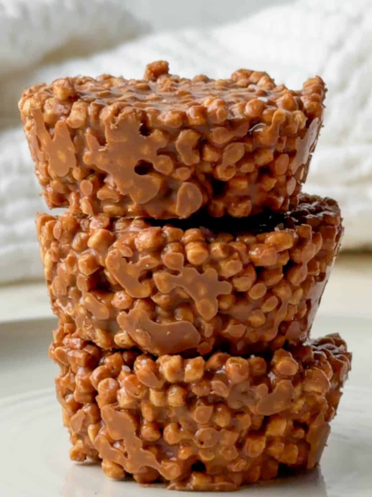Pea protein chocolate crispie cakes stacked on top of each other with a crunchy chocolate coating made from puffed pea protein cereal.