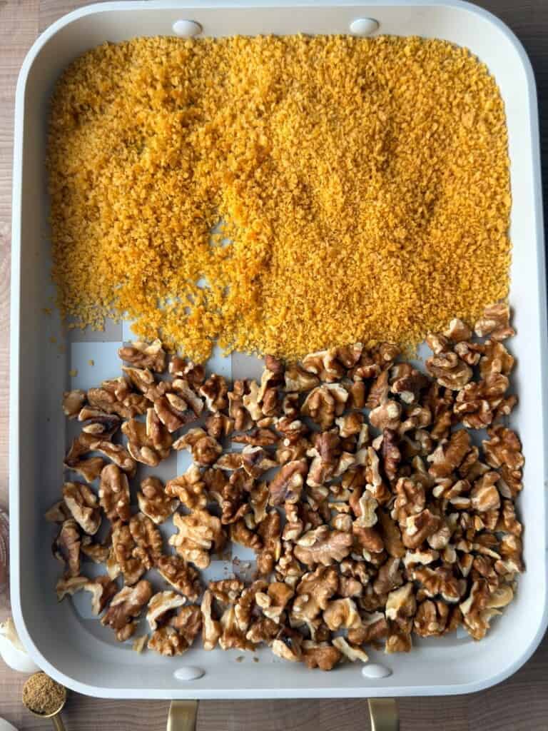 Toasted walnuts and panko breadcrumbs on a baking tray for a muhammara recipe.